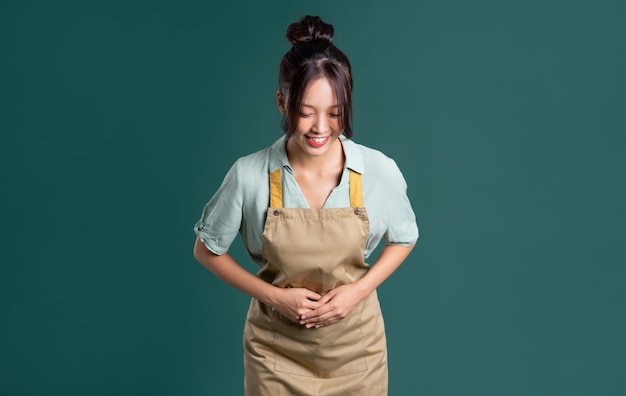 Portrait of asian woman wearing apron on green background