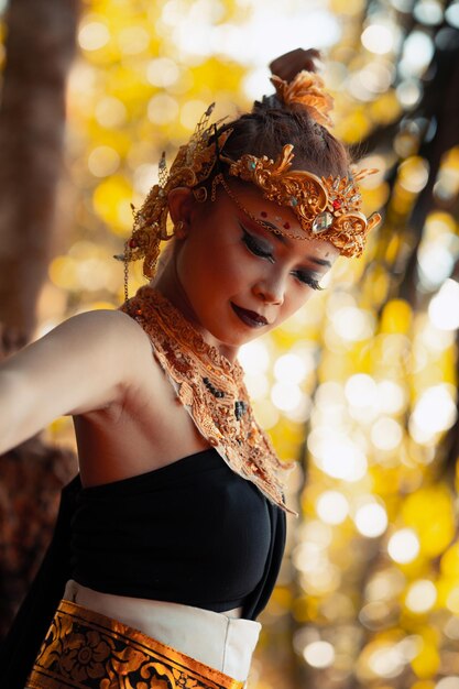 Portrait of Asian woman wearing a gold crown and gold necklace with her gorgeous makeup in black dress