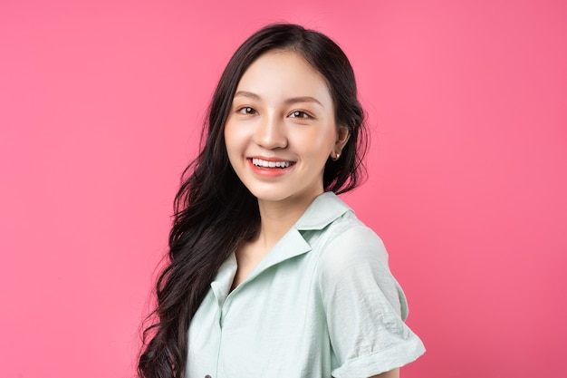 Portrait of an Asian woman with a confident look on pink