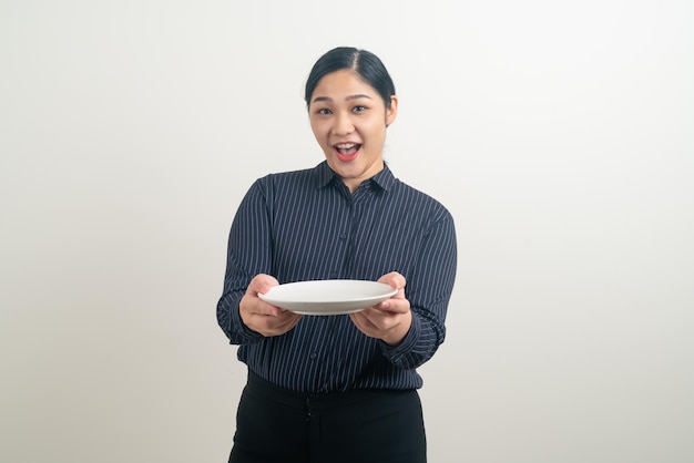 手に空のプレートを持つ肖像画アジアの女性