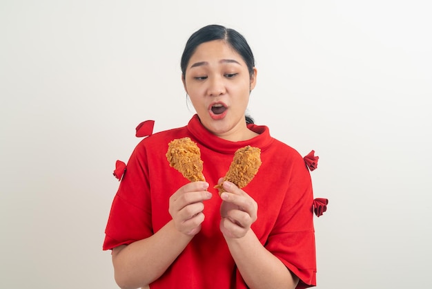 портрет азиатской женщины с жареным цыпленком под рукой