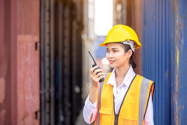 Ritratto di donna lavoratrice asiatica in uniforme di sicurezza che parla con walkie talkie