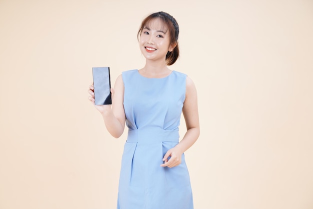 Portrait of Asian young beautiful and cheerful woman using smart phone isolated on background