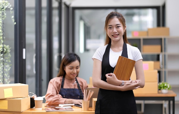 Portrait of Asian young woman SME working with a box at home the workplacestartup small business owner small business entrepreneur SME or freelance business online and delivery concept