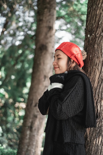 Portrait of Asian young woman in winter costume praying in the morning at the woodland Christianity and faith hope love concept