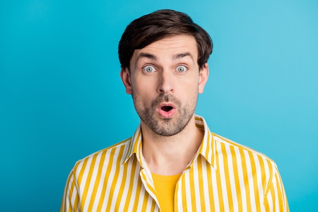 Portrait of astonished man see wonderful black friday sales open mouth look good wear striped yellow shirt isolated over blue color background