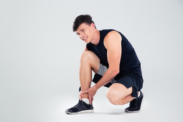 Portrait of athlete man suffering from pain in leg isolated