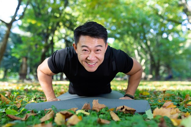 Portrait of an athlete in the park an asian man looks at the camera and smiles a man in a sports