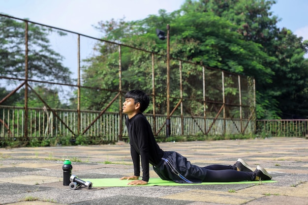 Портрет спортивного парня, практикующего йогу на открытом воздухе