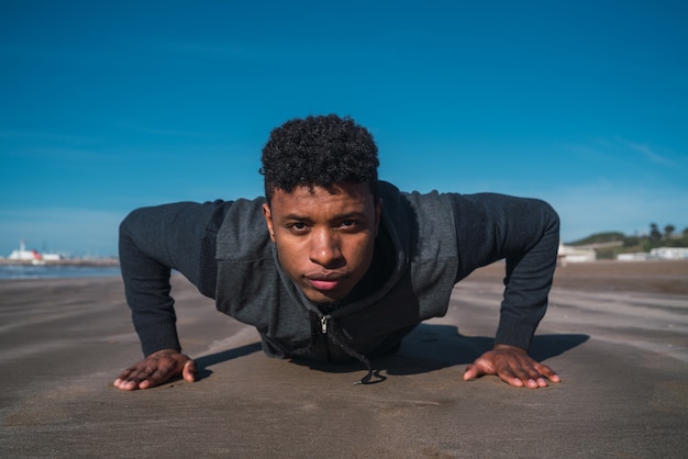 Portrait of an athletic man doing push-ups at the beach.