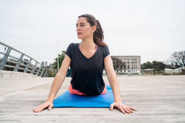Портрет спортивной женщины упражнения с циновкой для йоги. Концепция спорта и здорового образа жизни.
