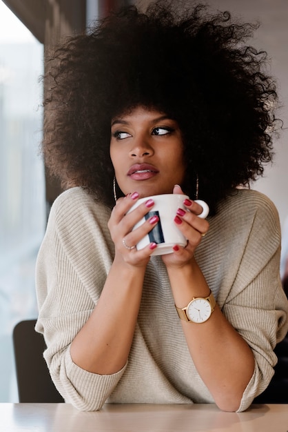 Portrait of attractive afro woman in coffee shop. Businesswoman concept