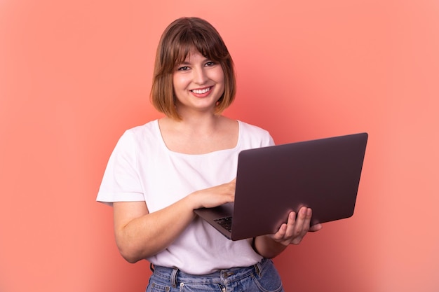 Portrait attractive amazed cheerful girl agent broker using laptop having fun pink pastel background