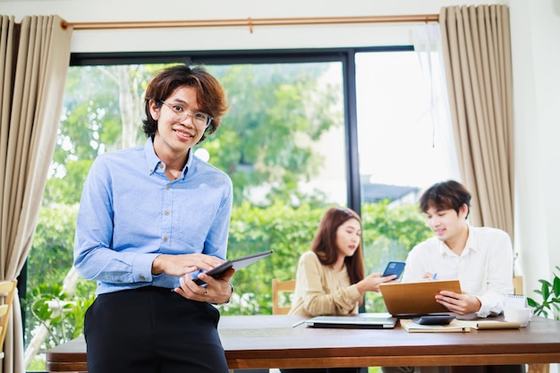 집에서 책상에 서 있는 매력적인 아시아 사업가의 초상화 중소기업 및 팀워크