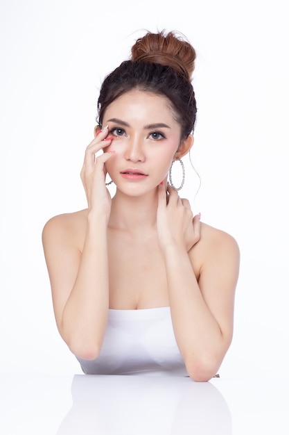 Photo portrait of attractive asian woman sitting smiling on white background.