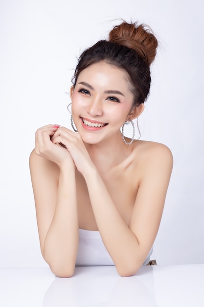 Photo portrait of attractive asian woman sitting smiling on white background