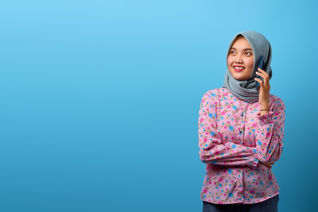 Portrait of attractive Asian woman talking on smartphone and looking happy