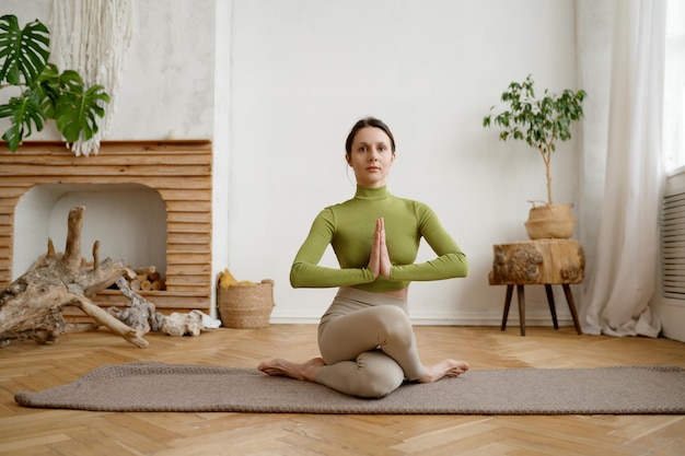 Photo portrait of attractive athlete woman practicing gomukhasana cow yoga pose folding hands anjali mudra of gratitude