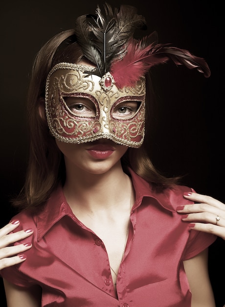 Портрет привлекательной красивой молодой женщины носить красную холодную карнавальную маску