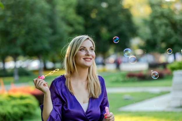 Ritratto di una donna bionda attraente nel parco pubblico