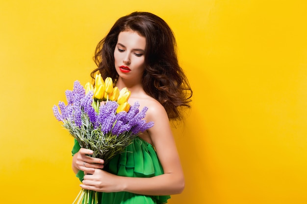 Portrait of attractive brunette in green dress with beautiful flowers