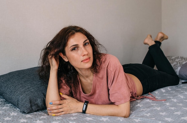 Portrait of an attractive brunette woman at home posing and looking at camera