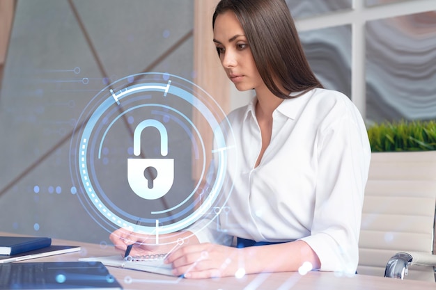 Portrait of attractive businesswoman working with documents and\
thinking how to protect clients confidential information and cyber\
security it hologram padlock icons over office background