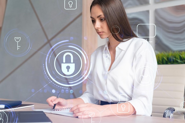 Portrait of attractive businesswoman working with documents and\
thinking how to protect clients confidential information and cyber\
security it hologram padlock icons over office background