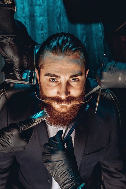 Portrait of an attractive charming man with a mustache and beard in a barbershop. Around the face of the barbershop. Style concept