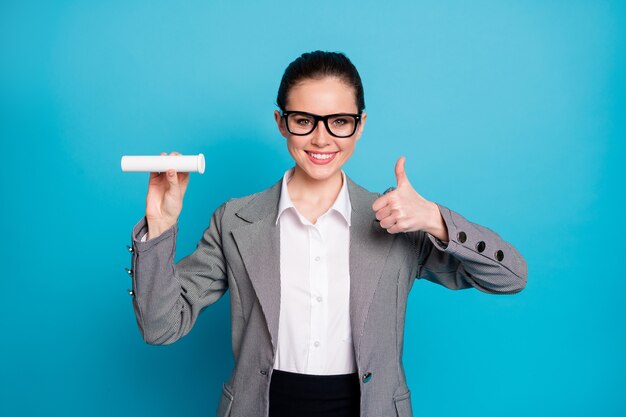 Portrait of attractive cheerful content lady demonstrating vitamin tube showing thumbup isolated on bright blue color background