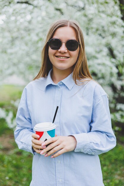 Portrait of attractive cheery dreamy girl drinking hot latte beverage resting strolling pastime on fresh air outdoors