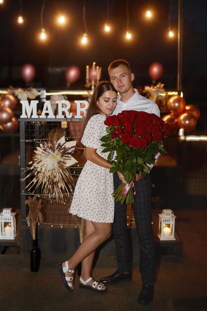 Photo portrait of an attractive couple holding bouquet of roses