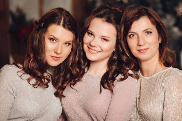 Portrait of attractive daughters and their mother in pastel shades with make up and hairstyles