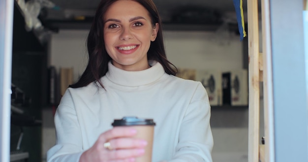 Portrait of attractive female barista holding beautiful coffee to go barista coffee shop lifestyle coffee creations