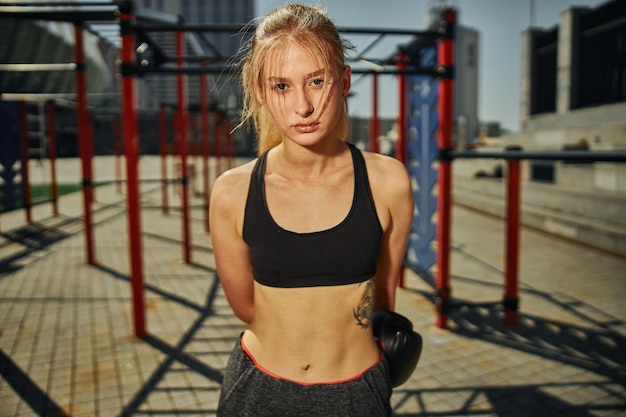 Portrait of attractive female who is finished kickboxing training  on sport ground