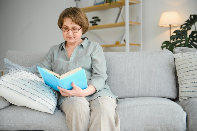 Portrait of attractive focused cheerful woman sitting on divan reading book pastime daydream at home house flat indoor