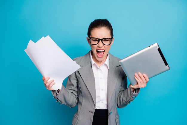 Portrait of attractive furious mad crazy lady specialist managing documentation burn-out isolated on bright blue color background