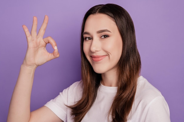 Portrait of attractive girl happy positive smile show okay alright sign isolated over violet color background