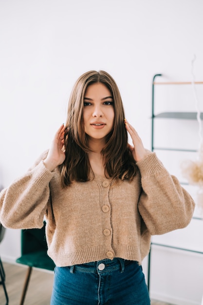 Photo portrait of attractive happy caucasian woman with brunette hair in bright living room