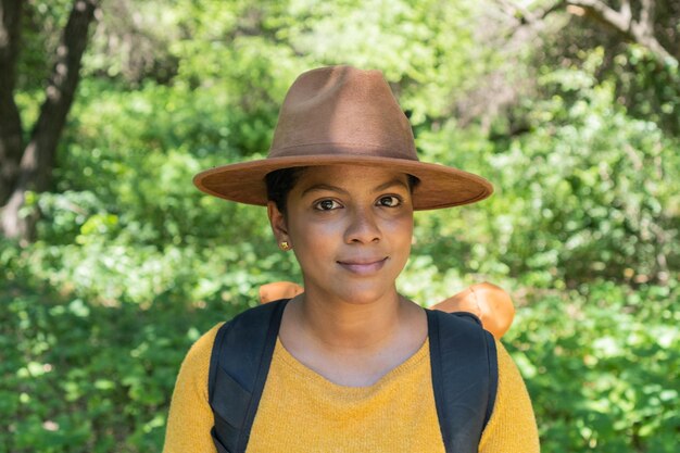 Portrait of an attractive hiker backpacking standing outdoors on an autumn day looking at the camera