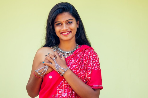 Portrait of attractive indian female model in vacation on\
paradise tropical beach by ocean sea. hindu woman with kundan\
jewelry set traditional india costume red wedding sari.asian girl\
sensual look