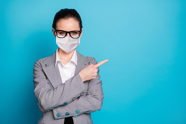 Portrait of attractive lady demonstrating copy space decision advert advice wear mask isolated over bright blue color background