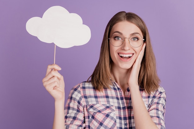 Portrait of attractive lovely lady happy positive smile hold clouds bubble news isolated on violet color background