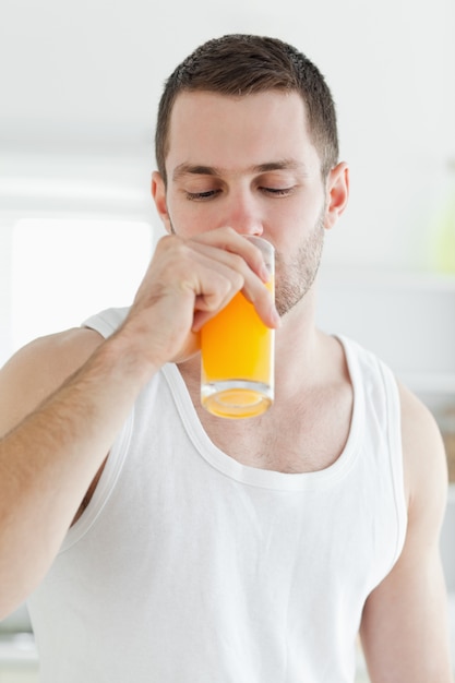 portrait of an attractive man drinking orange juice