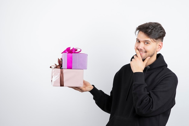 Портрет привлекательного мужчины, держащего две подарочные коробки