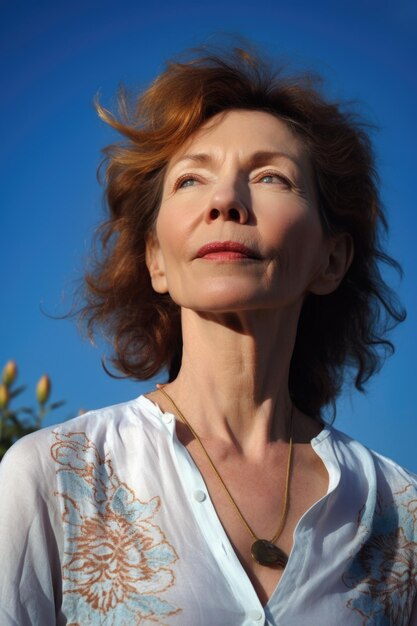 Portrait of an attractive mature woman in a yoga position against a blue sky background