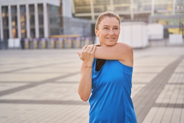 Premium Photo  Portrait of sportswoman smiling outdoors in morning. female  in running outfit standing outdoors in city.