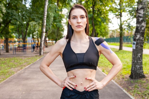 Portrait of attractive muscular brunette woman wearing black sports outfit