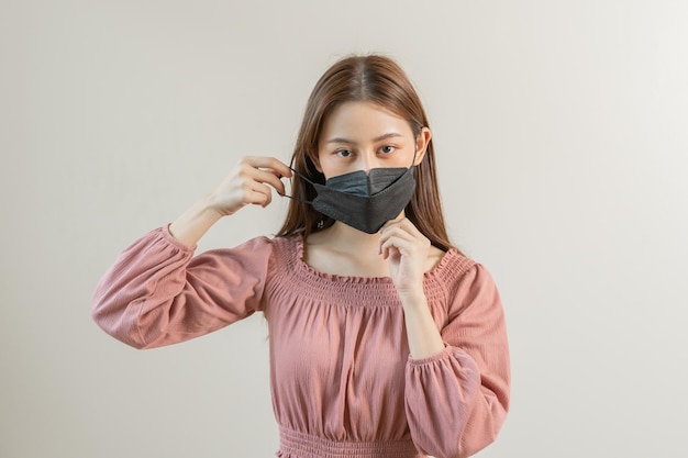 마스크를 쓴 매력적인 아시아 젊은 여성 10대의 초상화는 흰색 배경 복사 공간에 격리된 분홍색 티셔츠 건강 관리 예방에서 바이러스 백신 covid19 인플루엔자를 보호합니다.