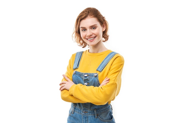 Portrait of attractive redhaired girl in yellow casual smiling joyfully isolated on white studio background